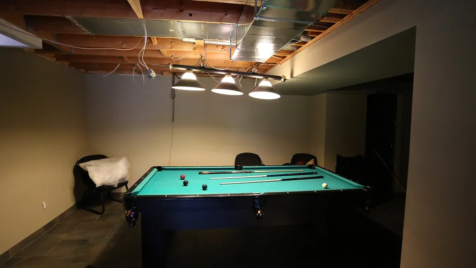 Poolbillardtisch in einem Keller-Hobbyraum mit niedriger Decke