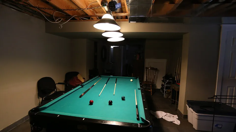 Poolbillardtisch in einem Hobbykeller mit niedriger Kellerdecke und begrenztem Durchgang