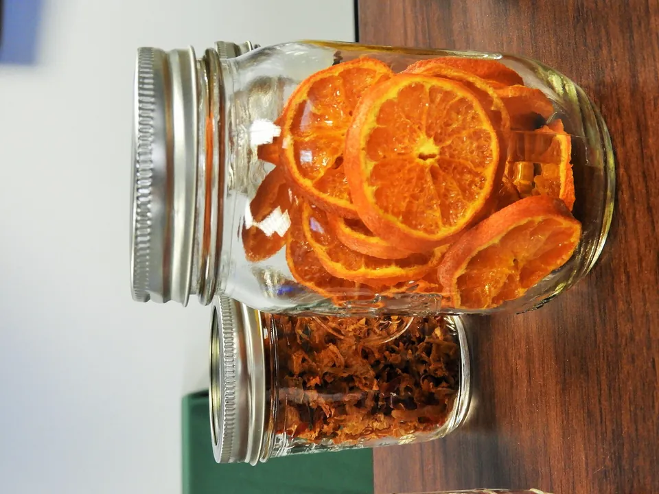 Getrocknete Orangenscheiben und Gemüsestreifen im Schraubglas