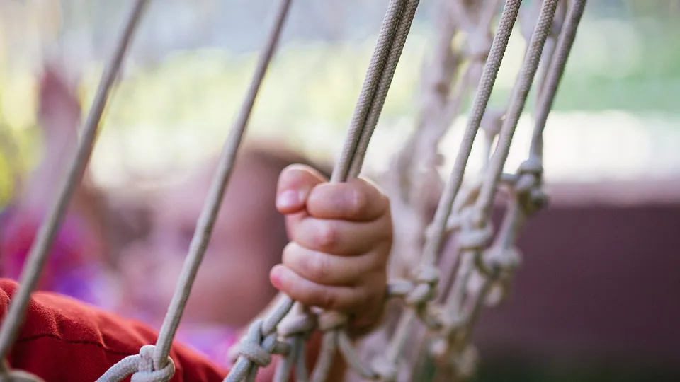 Kinderhand hält die Kordeln einer Hängematte